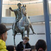 Male student taking notes in front of statue at Capitoline Museum in Rome