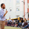 Male professor speaking to students sitting outside in a circle in Portugal