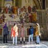 A group of students and their professor look up at the frescos at the Vatican Museum