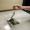 Ink-covered hand removing photo from printmaking stamp